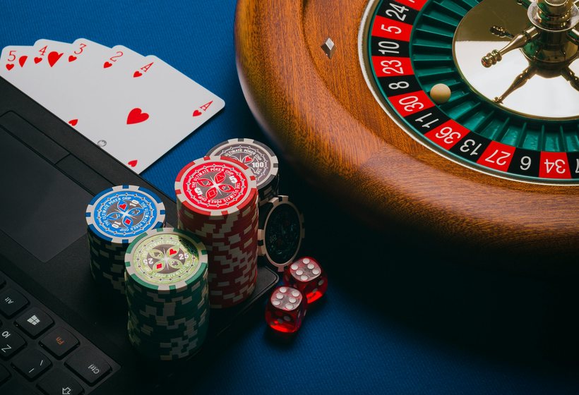 A Royal X player holding cards beside stacked promotional chips